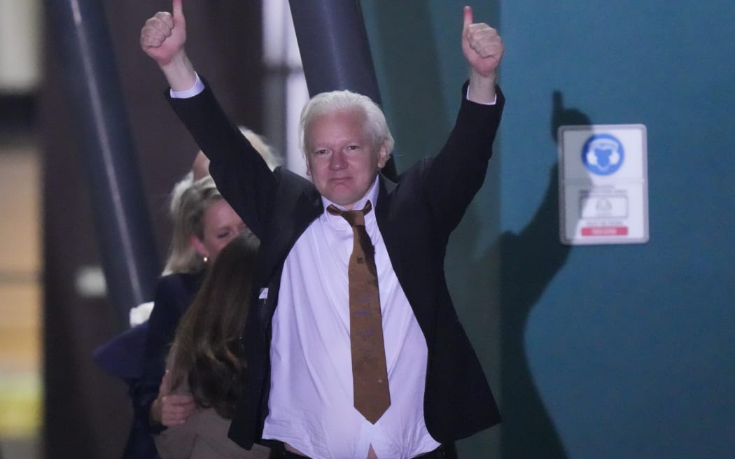WikiLeaks founder Julian Assange gestures after landing in Canberra, Australia, on 26 June 2024.