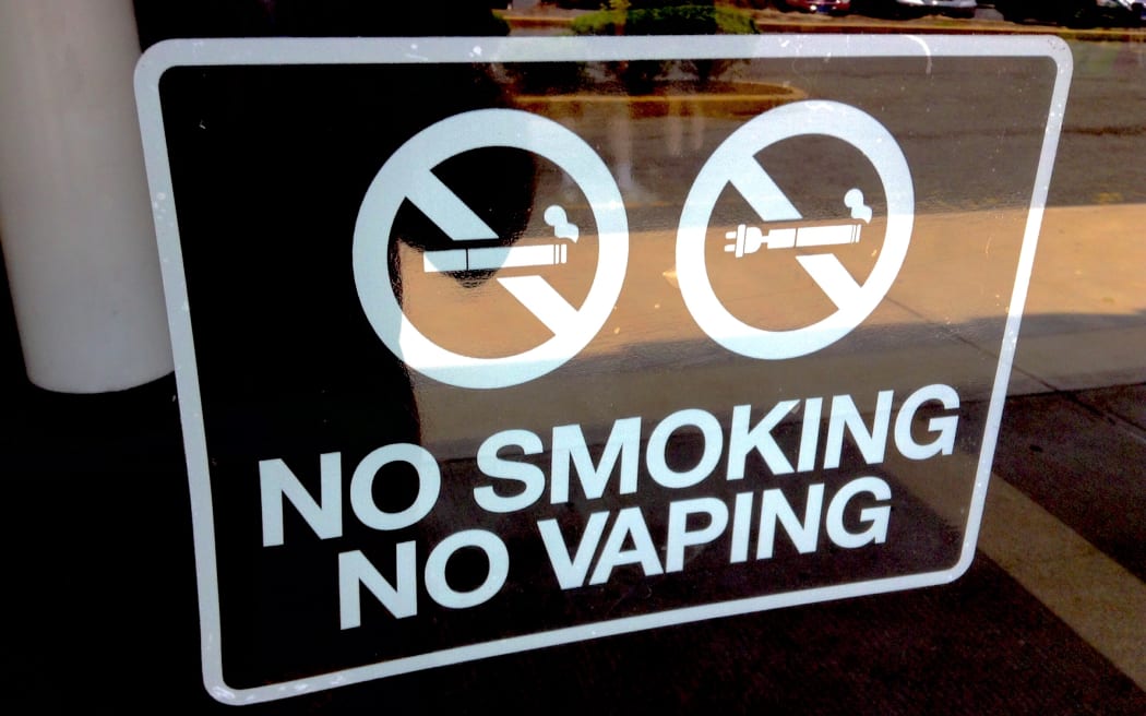 A sign in bold lettering reading "No Smoking / No Vaping".
