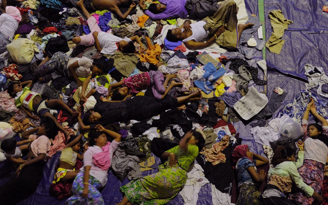 Rescued migrants sleep at a government sports auditorium in Indonesia's Aceh province.