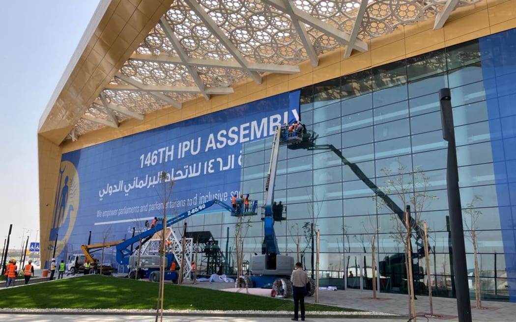 The IPU Assembly banner goes up on the conference centre in Bahrain.