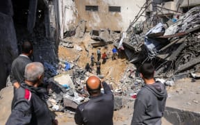 People search for survivors in the rubble of a building destroyed in an overnight Israeli strike in Jabalia, in the northern Gaza Strip on March 18, 2025. Israel's deadly strikes on Gaza drew global condemnation on March 18, as it said it had "no alternative" other than to resume military operations in order to bring home hostages. (Photo by Bashar TALEB / AFP)