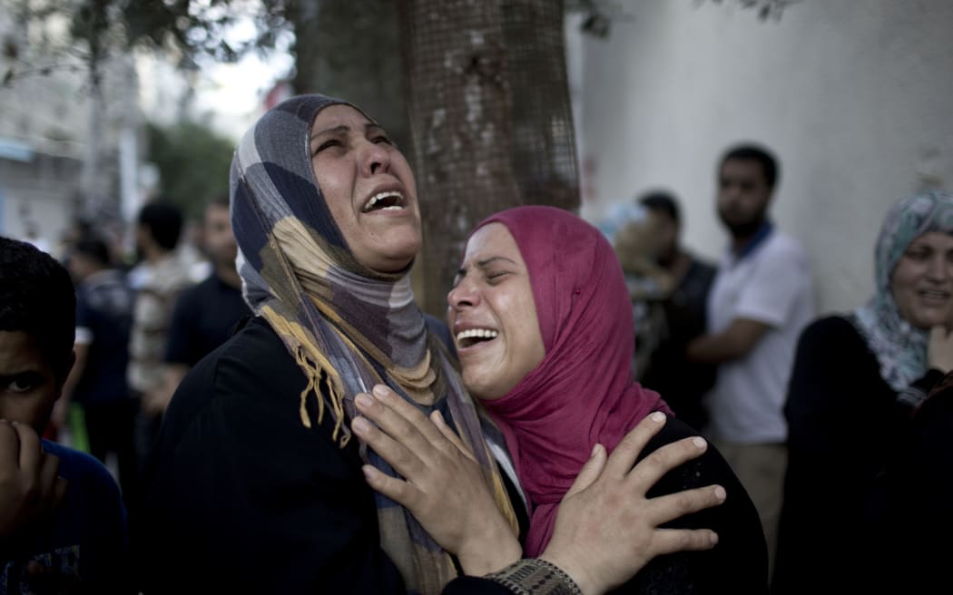 Distraught relatives outside a hospital morgue following the attack on the UN-run school