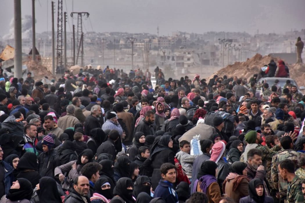 Syrian families, fleeing from various eastern districts of Aleppo, queue to get onto governmental buses on November 29, 2016 in the government-held eastern neighbourhood of Jabal Badro