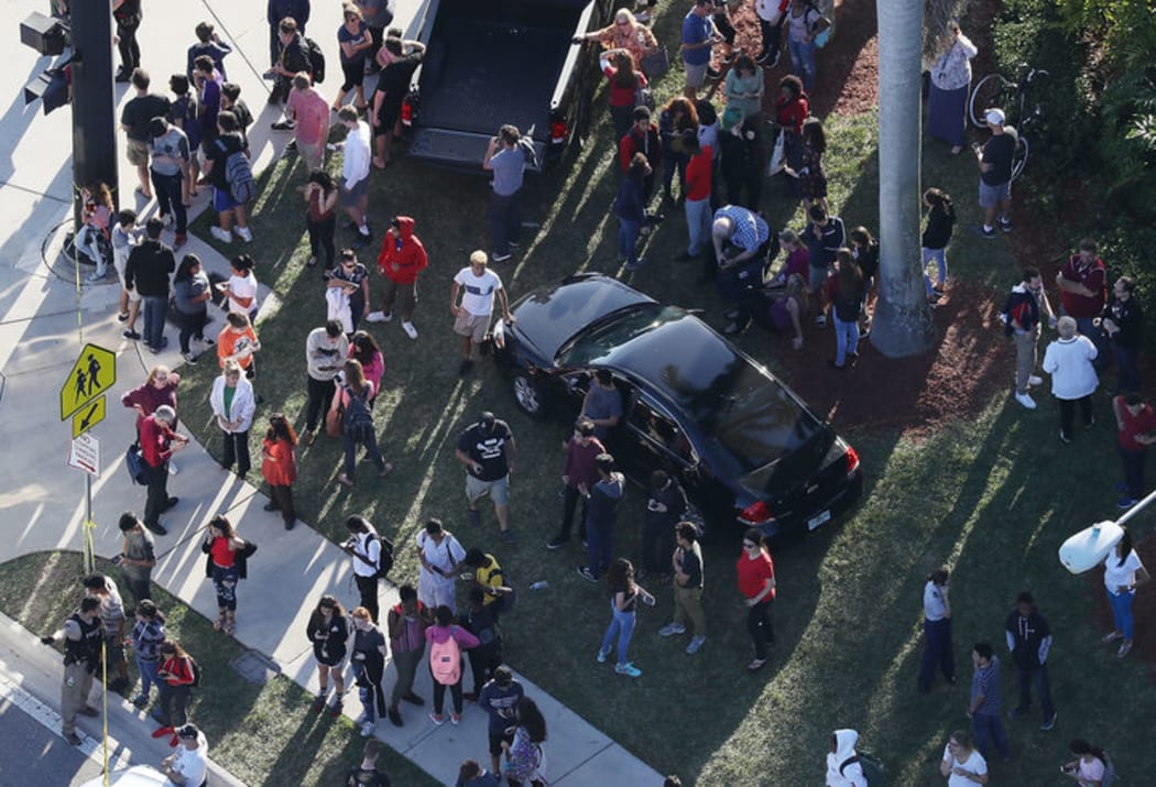People wait for loved ones as they are brought out of the Marjory Stoneman Douglas High School after the shooting.