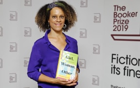 British author Bernardine Evaristo poses with her book 'Girl, Woman, Other' that won her the 2019 Booker Prize for Fiction