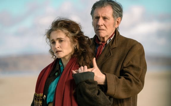 Helena Bonham Carter, as Margaret Gore, in Four Letters of Love, holding the hand of Gabriel Byrne, as Muiris Gore, standing behind her.