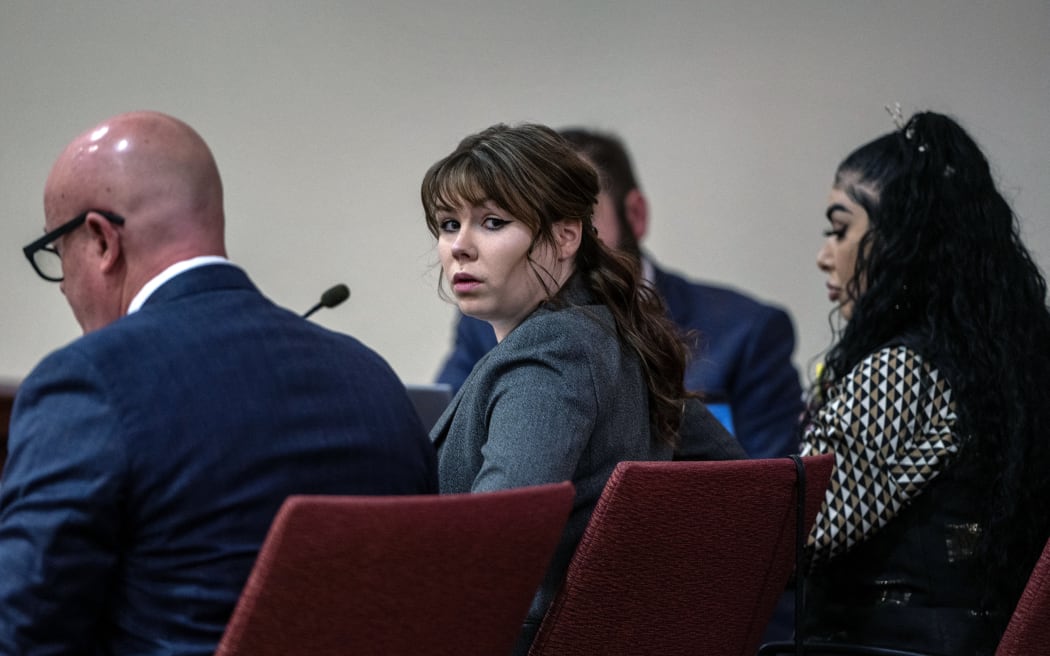 SANTA FE, NEW MEXICO - FEBRUARY 22: Hannah Gutierrez-Reed, center, sits with her attorney Jason Bowles, left, during the first day of testimony in the trial against her at First Judicial District Courthouse on February 22, 2024 in Santa Fe, New Mexico. Gutierrez-Reed, who was working as the armorer on the movie "Rust" when a revolver actor Alec Baldwin was holding fired killing cinematographer Halyna Hutchins and wounded the film's director Joel Souza, is charged with involuntary manslaughter and tampering with evidence.   Eddie Moore-Pool/Getty Images/AFP (Photo by POOL / GETTY IMAGES NORTH AMERICA / Getty Images via AFP)
