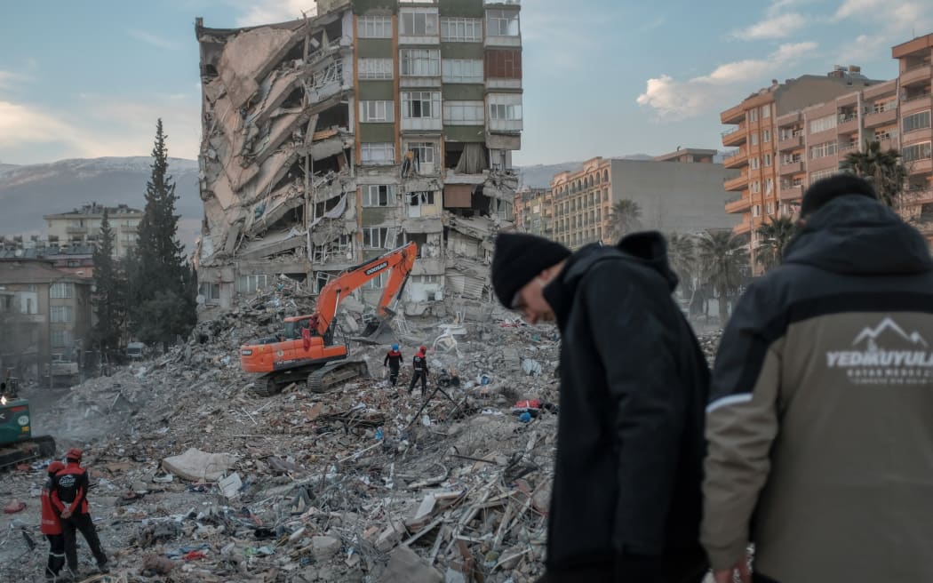 Rescuers search through the rubble of a collapsed building in Kahramanmaras on February 18, 2023, after a 7,8-magnitude earthquake struck the country's south-east. - The death toll on February 18 rose to more than 44,000 from the devastating earthquake in Turkey and Syria in the early hours of February 6, 2023. (Photo by BULENT KILIC / AFP)