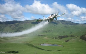 A fixed-wing aircraft is used to drop fertiliser on a field.