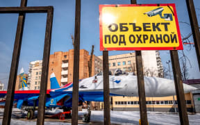 A Sukhoi Su-27 fighter jet of "The Russian Knights" aerobatic team is seen behind a fence with a warning sign reading "The object is protected" in Moscow on March 15, 2019. (Photo by Yuri KADOBNOV / AFP)