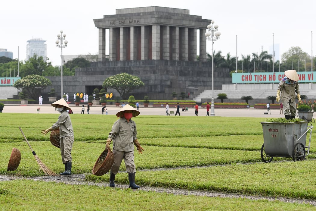 Workers tend to grass at Ba Dinh square outside the Ho Chi Minh mausoleum in Hanoi, on May 13, 2020, as tourist spots began reopenin.