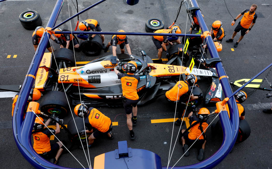 McLaren's team work on the car of driver Oscar Piastri.