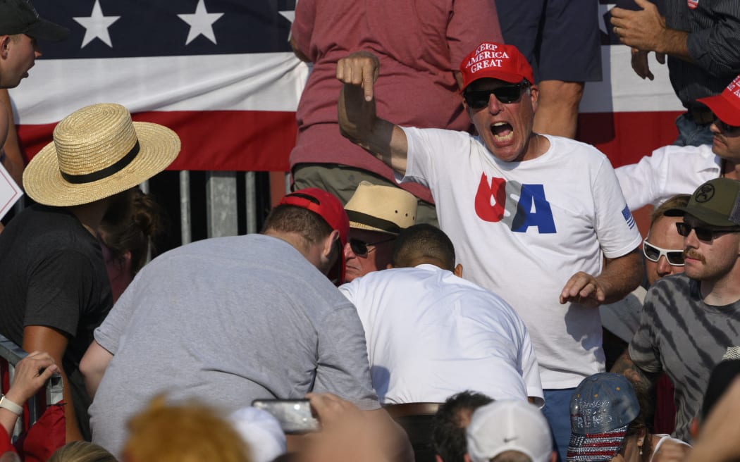 BUTLER, PENNSYLVANIA - JULY 13: Attendees scatter after gunfire rang out during a campaign rally for Republican presidential candidate, former U.S. President Donald Trump at Butler Farm Show Inc. on July 13, 2024 in Butler, Pennsylvania. Trump slumped before being whisked away by Secret Service with injuries visible to the side of his head. Butler County district attorney Richard Goldinger said the shooter and one audience member are dead and another was injured.   Jeff Swensen/Getty Images/AFP (Photo by JEFF SWENSEN / GETTY IMAGES NORTH AMERICA / Getty Images via AFP)