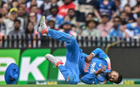 India's Shreyas Iyer falls on the ground injured after taking a catch to dismiss Australia's Alex Carey during the third one-day international at the Sydney Cricket Ground, October 25, 2025. (Photo by Saeed KHAN / AFP)