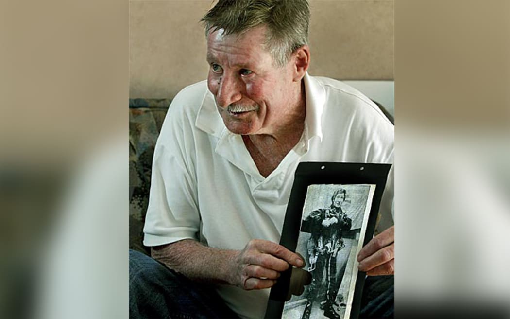 Pioneering skydiver Kevin 'Cotty' Cottrell in 2013, with a picture of himself before his record-setting skydive in 1976.