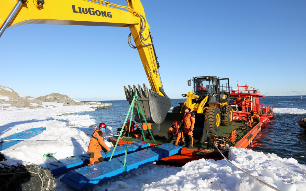 (180117) -- ABOARD XUELONG, Jan. 17, 2018 (Xinhua) -- Members of China's 34th Antarctic expedition land an excavating loader on the Inexpressible Island on Jan. 16, 2018. Large engineering equipments on Tuesday were transfered from China's research icebreaker Xuelong to the Inexpressible Island, where the country's 5th research station will begin construction near the Ross Sea in the Antarctic.
The new base is expected to set up within five years, and will provide year-round support for researchers conducting tasks such as observations of land, ocean, atmosphere, ice shelf and biology, establishment of an observation and monitoring network in the Antarctic, and survey of marine environmental protection.  (Xinhua/Bai Guolong) (wf) (Photo by Bai Guolong / XINHUA / Xinhua via AFP)