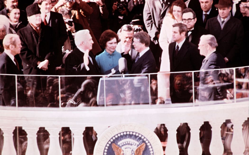 Jimmy Carter is sworn in on January 20, 1977, by Supreme Court Chief Justice Warren Burger (L) in front of the US Capitol in Washington, DC, as the 39th President of the United States. Carter’s wife, Rosalynn Carter (C), holds the bible belonging to his mother, Lillian Carter. Jimmy Carter was elected President of the United States on November 2, 1976, with 51% of votes against 48% for incumbent President Gerald Ford. (Photo by CONSOLIDATED NEWS / AFP)