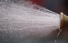 Groundstaff members sprays water on the tennis court during the men's singles first round match on day 1 of The Roland Garros 2019 French Open tennis tournament in Paris on May 26, 2019. (Photo by Kenzo TRIBOUILLARD / AFP)