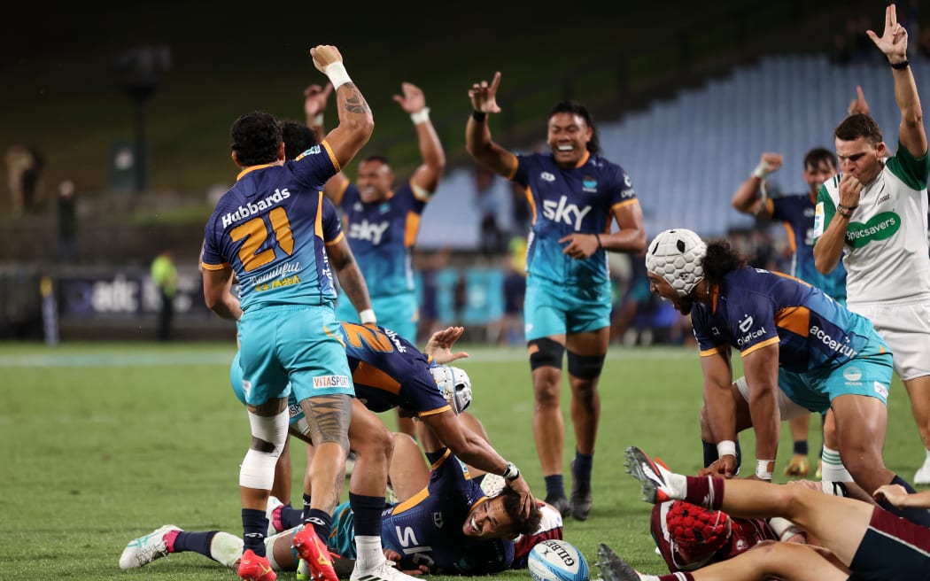 Moana Pasifika celebrate the winning try against the Reds.