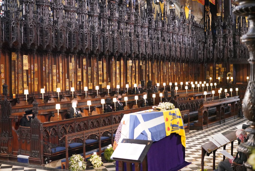 The Queen sits alone on the left during the funeral service for Prince Philip in St George's Chapel at Windsor Castle.