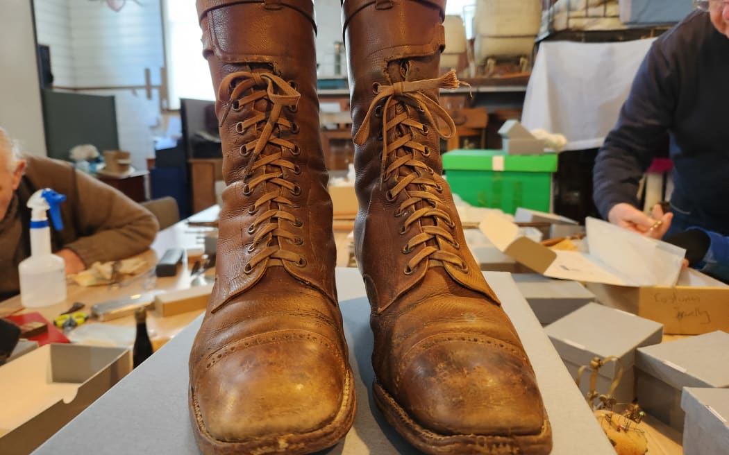 A pair of lace-up tan coloured antique boots on the work table