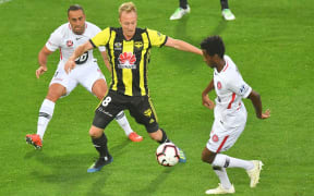 Phoenix player Mitch Nichols battles for possession with a pair of Western Sydney Wanderers rivals.