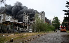 Firefighters extinguish a fire at a civilian plant following Russian powerful attacks to Ukrainian city of Kharkiv early on June 7, 2025. amid Russian invasion in Ukraine. Russia pummelled Ukraine's second-largest city before dawn on June 7, killing two people in what Kharkiv's mayor described as the "most powerful attack" there since the start of the war. (Photo by SERGEY BOBOK / AFP)