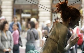 British performance artist Alice Newstead hangs from shark fishing hooks to protest shark finning in 2008.
