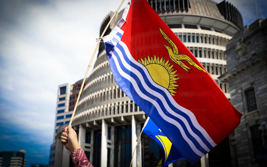 The Kiribati flag is waved in front of the Beehive in Wellington.