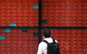 A man looks at an electronic quotation board displaying stock prices of Nikkei 225 on the Tokyo Stock Exchange in Tokyo on August 6, 2024. Tokyo stocks bounced back in early trade on August 6 following a historic selloff on worries over the US economy and a stronger yen. (Photo by Kazuhiro NOGI / AFP)