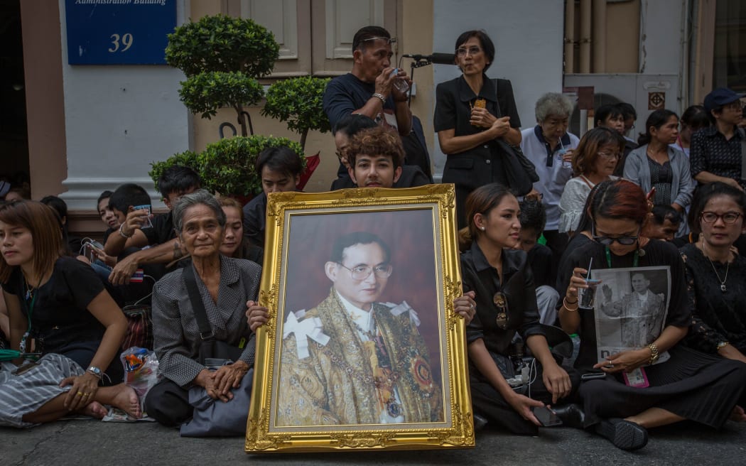 Thai Royalists and well-wishers gather inside Siriraj Hospital while carrying portraits of the King to await the funeral procession.