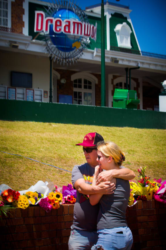 People hug outside Dreamworld after four people were killed at the Queensland theme park.
