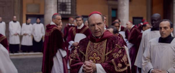 Ralph Fiennes as a Cardinal with other Cardinals looking on.