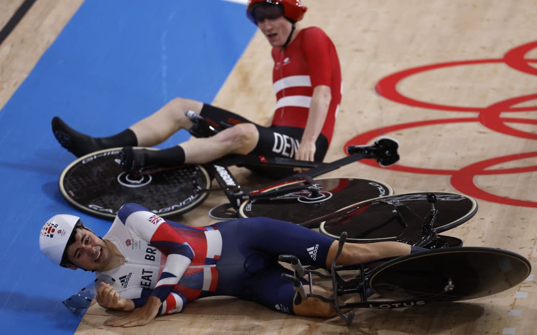 Denmark's Frederik Madsen crashes with Great Britain's Charlie Tanfiled (bottom) during the first round heats of the men's track cycling team pursuit during the Tokyo 2020 Olympic Games at Izu Velodrome in Izu, Japan, on August 3, 2021.