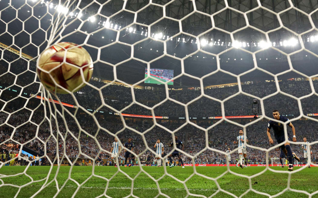 France's forward #10 Kylian Mbappe (2R) scores a penalty goal during the Qatar 2022 World Cup final football match between Argentina and France at Lusail Stadium in Lusail, north of Doha on December 18, 2022.