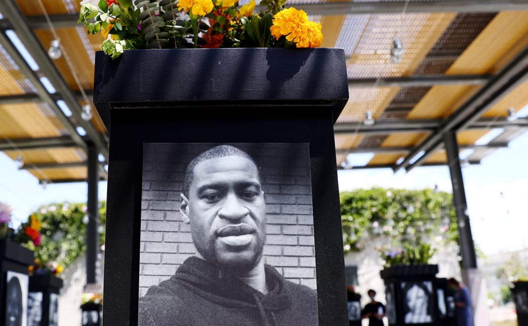 SAN DIEGO, CALIFORNIA - JULY 20: A photograph of George Floyd (C) is displayed along with other photographs at the Say Their Names memorial exhibit at Martin Luther King Jr. Promenade on July 20, 2021 in San Diego, California. )