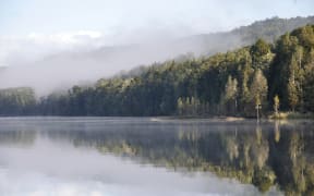 early morning mist on Lake Haupiri, a small lake near the Southern Alps, West Coast, South Island, New Zealand.