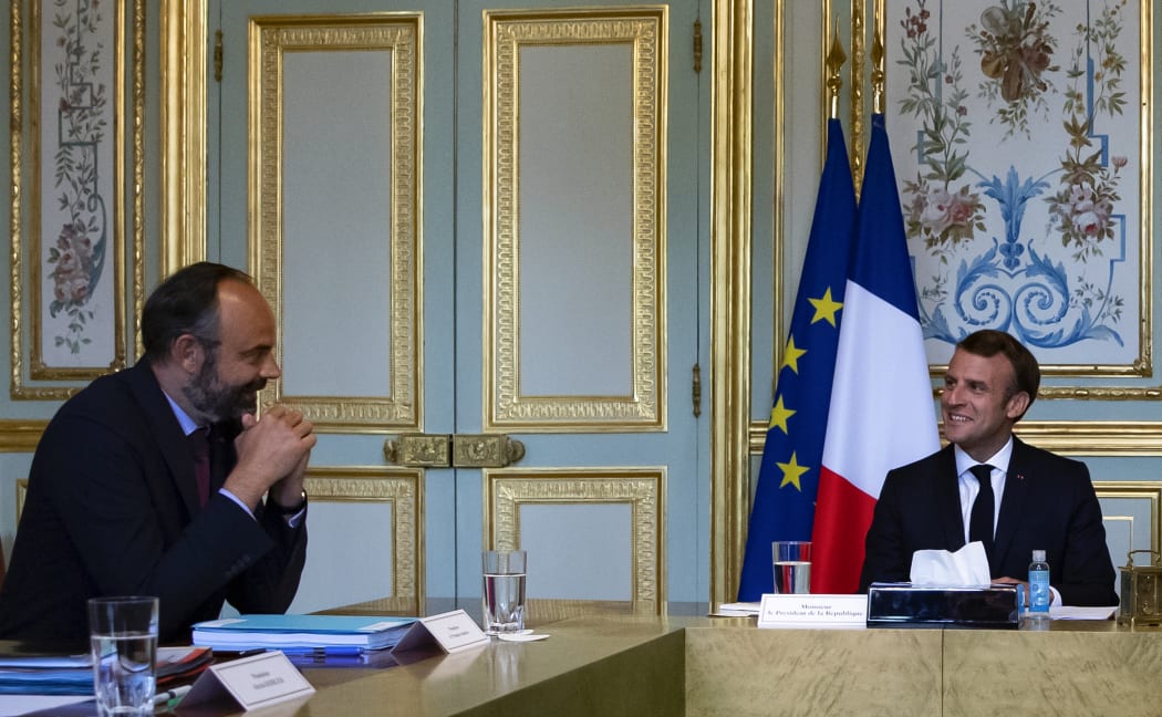 French President Emmanuel Macron (R) chats with French Prime Minister Edouard Philippe during a meeting.