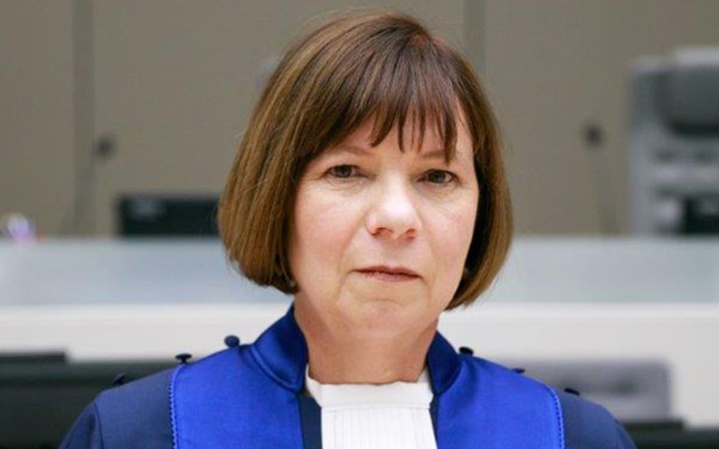 Woman with mid length straight dark hair in robes on International Criminal Court