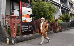 A pedestrian passes a for sale in Melbourne.