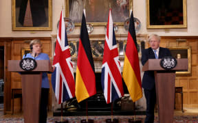 Britain's Prime Minister Boris Johnson (R) and German Chancellor Angela Merkel hold a joint press conference following their bilateral meeting at Chequers, Buckinghamshire on July 2,