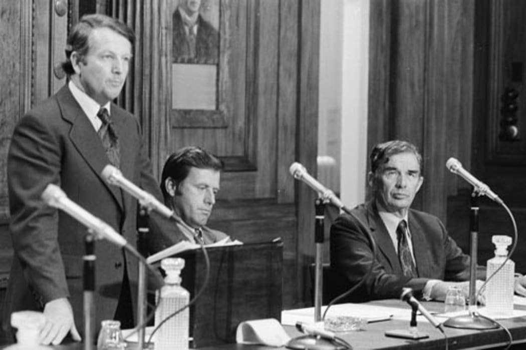 Prime Minister Bill Rowling delivers an outline of the Labour government’s economic policy in 1975 with ministers Colin Moyle (centre) and Michael Connelly (right) seated beside him.