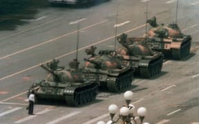 FILE - In this June 5, 1989, file photo, a Chinese man stands alone to block a line of tanks heading east on Beijing's Changan Blvd. in Tiananmen Square