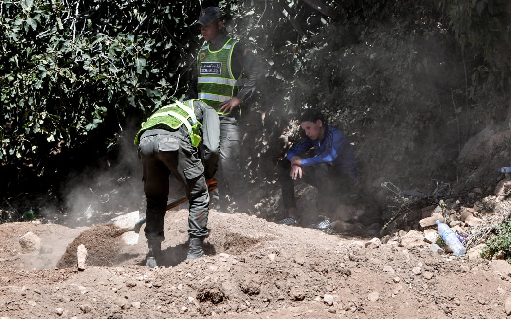 Members of Morocco's Royal Gendarmerie and Auxiliary Forces dig graves in the village of Tikht near Adassil in central Morocco for the burials of victims of the deadly 6.8-magnitude earthquake that hit on 8 September, 2023.