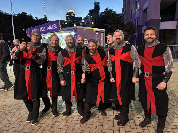 Eight men in knights' costumes.
