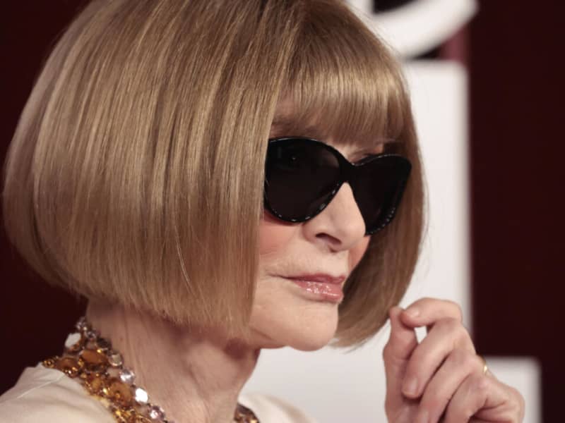 Anna WIntour looks sideways in big black sunglasses.