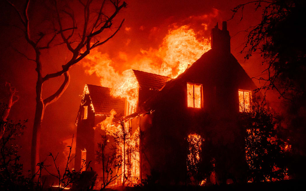 A home burns during the Eaton fire in the Altadena area of Los Angeles County, California on January 8, 2025. (Photo by JOSH EDELSON / AFP)