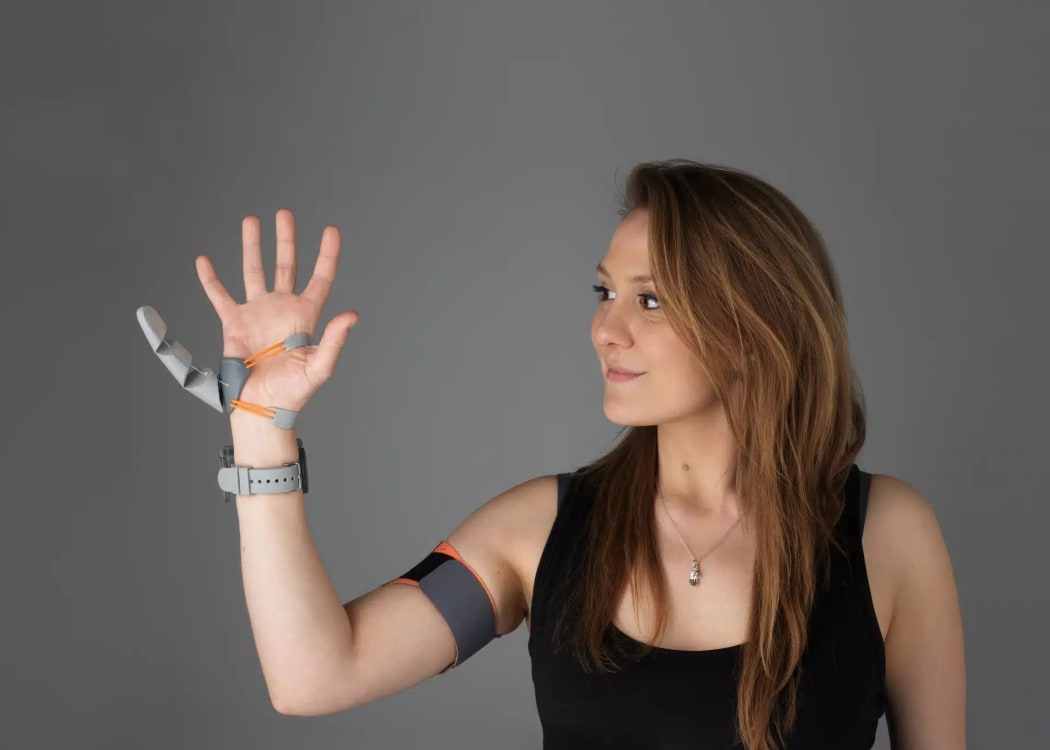 Dani Clode demonstrates her third thumb prosthetic.