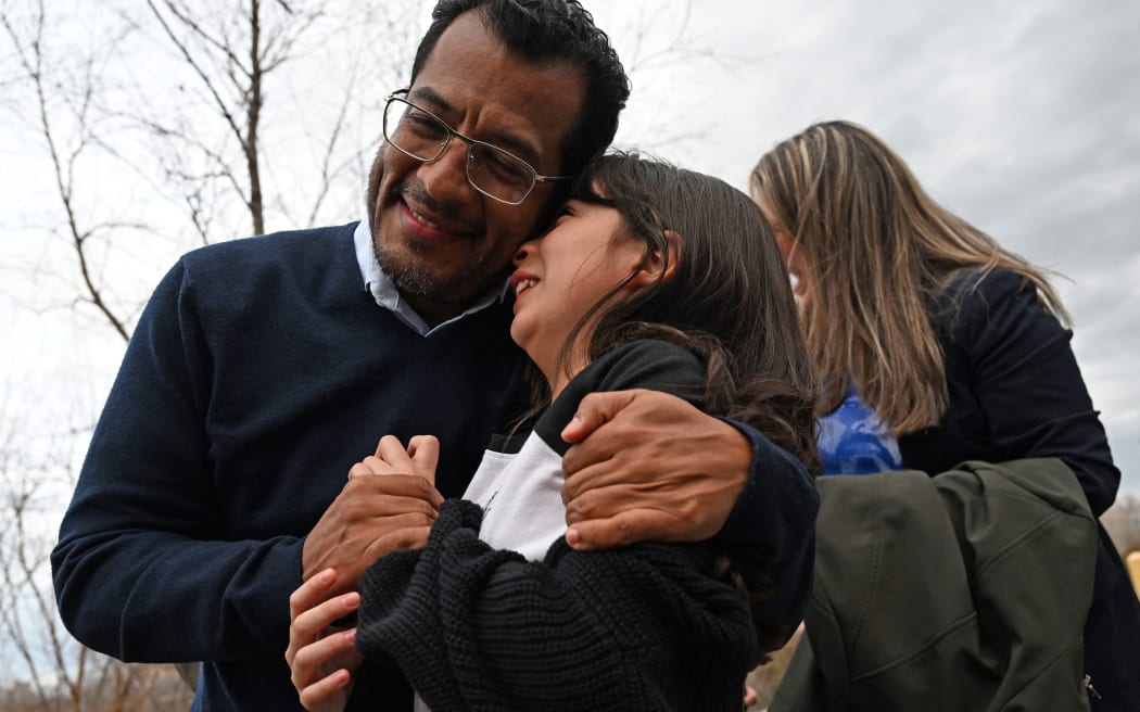 Nicaraguan scholar Felix Madariaga holds his daughter Alejandra,9, outside the Westin Hotel in Herndon, Virginia, on February 9, 2023. - More than 200 detained members of Nicaragua's opposition arrived in the US after being freed by authorities, family members and opposition figures said. "Two hundred and twenty-two political prisoners are coming to Washington, they were freed," Nicaragua's former ambassador to the Organization of American States Arturo McFields said in a video shared on social media. (Photo by ANDREW CABALLERO-REYNOLDS / AFP)