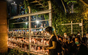 Tens of thousands of people across Hong Kong lit candles and chanted democracy slogans to commemorate China's deadly Tiananmen crackdown, defying a ban against gathering as tensions seethed over a planned new security law.